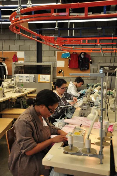 Étudiantes en Gestion et production du vêtement du Cégep Marie-Victorin qui travaille sur un morceau de vêtement.